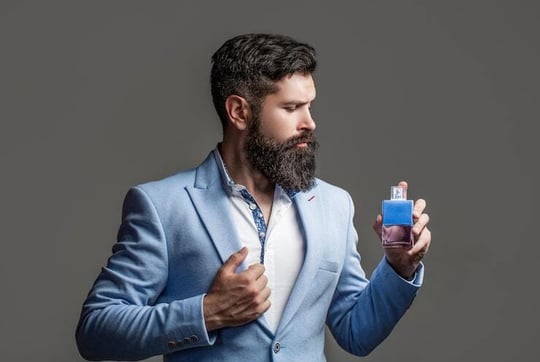 masculine-perfume-bearded-man-suit-copy-space-masculine-perfume-bearded-man-suit-perfume-cologne-bottle-perfumery-cosmetics-scent-cologne-bottle-male-holding-cologne_293990-2554